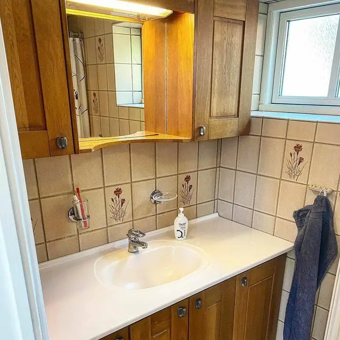 Detaliu baie cu gresie decorativă bej și oglindă în lemn stejar
