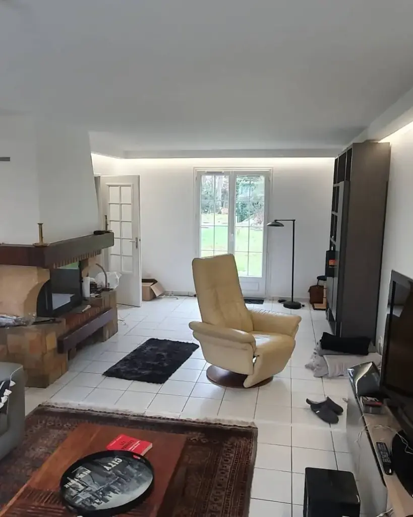 Bucătărie cu mobilier din lemn, blat gri, fereastră și iluminare caldă