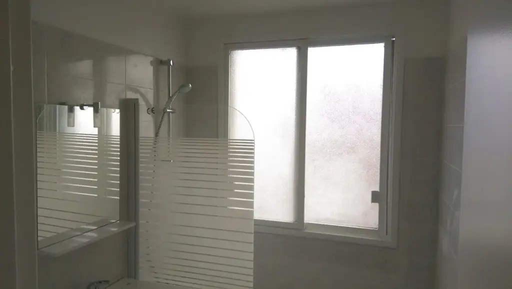 Cabină de duș cu sticlă mată și gresie albă