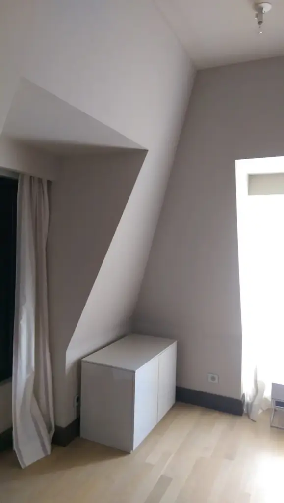 Cameră cu pereți și tavan finisați în tonuri neutre