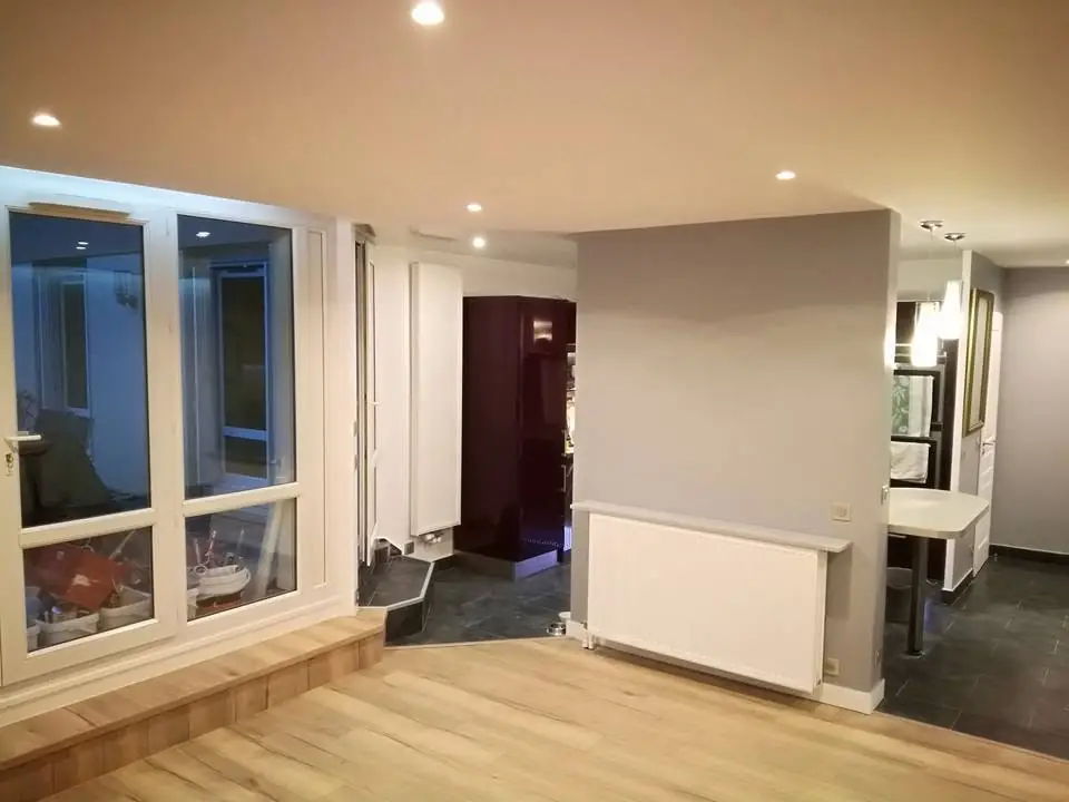 Living/hol finalizat cu pardoseală lemn deschis, tavan fals alb cu iluminare LED, pereți