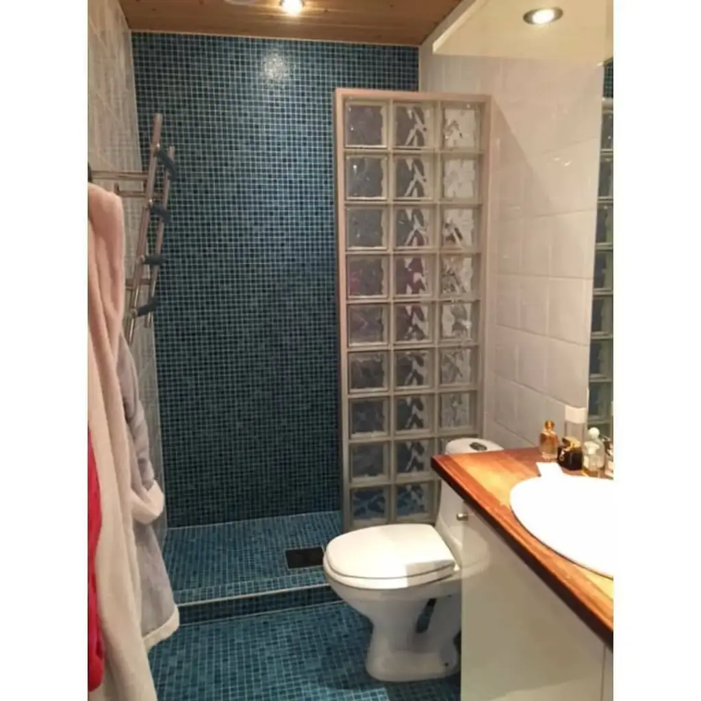 Baie cu gresie albastră, duș din sticlă, WC și mobilier functional