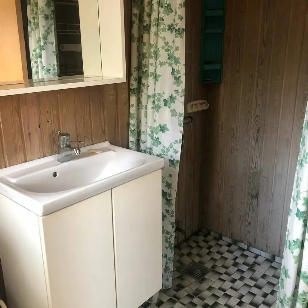 Baie cu chiuvetă pe perete, gresie decorativă, dulap alb, oglindă, material inegal cu