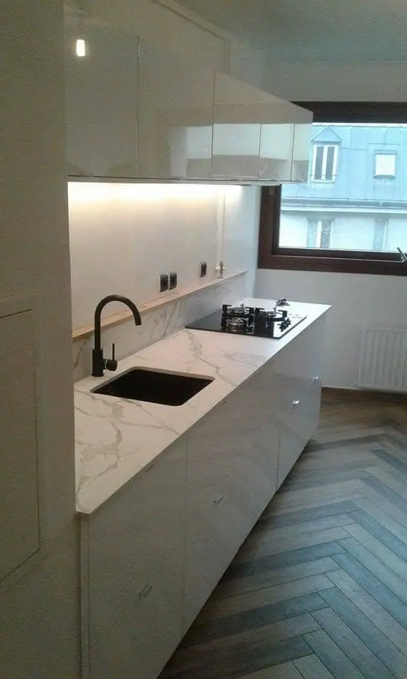 Bucătărie finalizată cu mobilier alb, plan de lucru marmura albă, backsplash alb cu