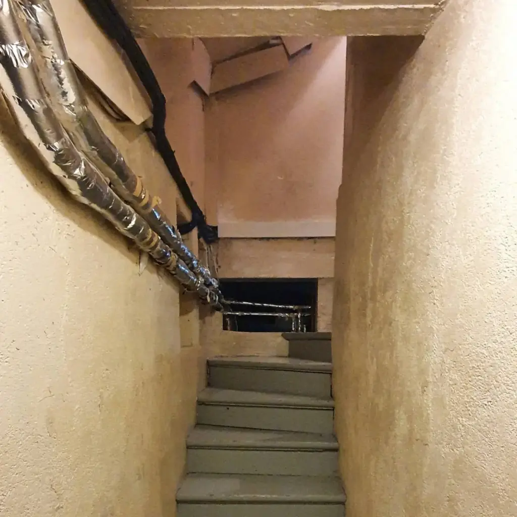 Scara în renovare cu tevi izolate cu folie argintie, trepte beton brut, praf