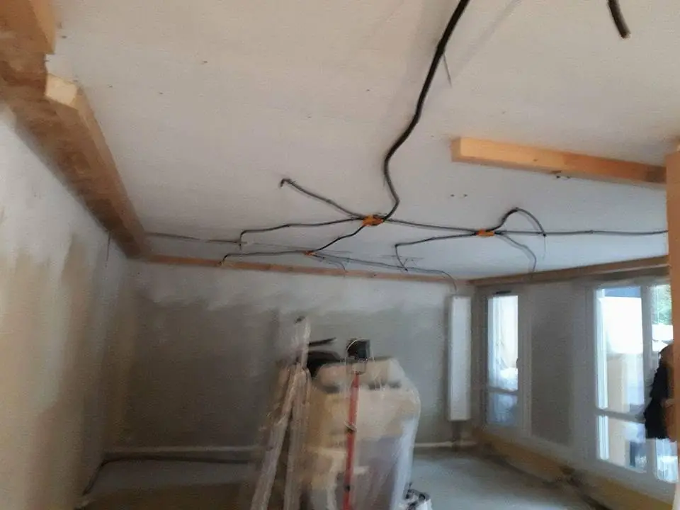 Cameră cu rigips incomplet, bare de susținere din lemn, cabluri electrice la vedere