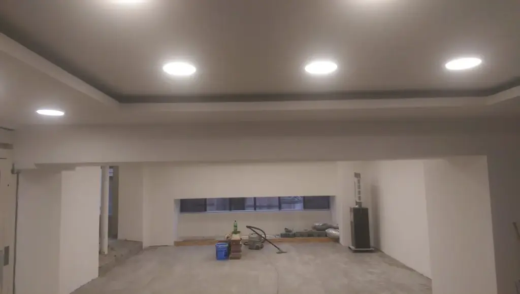 Interior în construcție cu tavan rigips, iluminare LED încorporată, perete interior gol cu